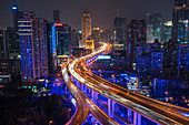 Erhöhte Straßenkreuzung und der Skyline von Shanghai in der Abenddämmerung, Shanghai, China