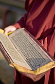 Mönch hält buddhistisches Gebetbuch, Rumtek Gompa, Gangtok, Sikkim, Indien, Asien