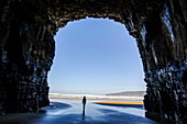 Frau steht in den gigantischen Höhlen der Kathedrale, The Catlins, Südinsel, Neuseeland, Pazifik