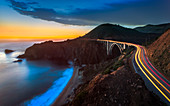 Sonnenuntergang über Bixby Creek Bridge und Autospurlichter, Big Sur, Kalifornien, Vereinigte Staaten von Amerika, Nordamerika
