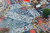 Aerial view of crowds crossing the famous Shibuya Crossing crosswalks at the centre of Shibuya's fashionable shopping and entertainment district, Shibuya, Tokyo, Japan, Asia