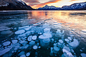 Bubbles and Cracks in the Ice with Elliot Peak in the Background at Sunset, Abraham Lake, Alberta, Canada, North America
