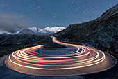Star trail and lights of car traces, Bernina Pass, Poschiavo Valley, Engadine, Canton of Graubunden, Switzerland, Europe