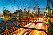 Hauptverkehrszeit in der Nacht auf der Brooklyn Bridge und der Skyline von Manhattan dahinter, New York City, Vereinigte Staaten von Amerika, Nordamerika