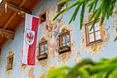 Österreichische Flagge und bunte Architektur in St. Johann in Tirol, Österreich, Europa