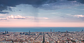 Skyline von Barcelona bei Sonnenuntergang mit Regenwolke\n