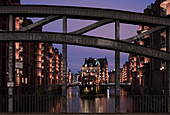 Hamburg Speicherstadt an der Poggenmühlen-Brücke mit Wasserschloss bei Sonnenuntergang, Deutschland