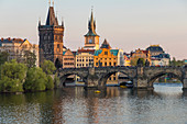 Blick über die Karlsbrücke, den Altstädter Brückenturm und die Moldau bei letztem Sonnenlicht, UNESCO-Weltkulturerbe, Prag, Böhmen, Tschechische Republik, Europa