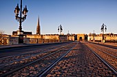 France, Gironde, Bordeaux, area listed as World Heritage by UNESCO, Pont de Pierre on the Garonne River, in the background Saint Michel church and the gate of Bourgogne