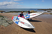 Stand-up paddlers with their boards at Milsey Bay, North Berwick, East Lothian