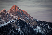 Berge im Sonnenuntergang mit Jakobskreuz in Fieberbrunn, Kaisergebirge bei Winter, Tirol, Österreich