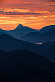 Mountain silhouettes of the Bavarian Prealps on Lake Walchensee in sunrise, from Jochberg