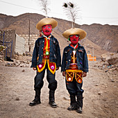 Arequipa, Peru - December 25, 2011: Two men wearing festive clothing and wearing red masks.