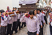 Cusco, Peru - 2. Januar 2012: Eine Gruppe von Männern trägt eine Sänfte auf einem Straßenfest