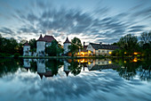 Abendlicher Blick von Osten auf die Blutenburg, mit Spiegelung in der Würm, München, Bayern, Deutschland