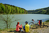 Frau und Mann beim Radfahren machen Pause am Inn, Benediktradweg, Oberbayern, Bayern, Deutschland