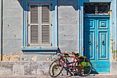 A wheel leaned against a house wall in Marsaxlokk, Malta