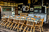 Table with wooden chairs in a closed tourist restaurant, Italy
