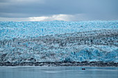 A Zodiac inflatable boat passes the front edge of the massive Pio XI glacier, Magallanes y de la Antartica Chilena, Patagonia, Chile, South America
