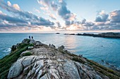 France, Ille-et-Vilaine, Cancale, hikers at tip of Grouin at sunrise