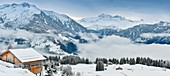 Frankreich, Savoie, Beaufortain, Hauteluce, Panoramablick über mehrere verschneite Holz-Chalets im Morgengrauen