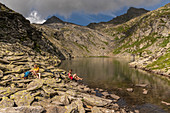 Group of hikers takes a break, Lago dells Froda, Trekking del Laghetti Alpini, Ticino, Switzerland