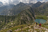 Hikers descend to Lago Bianco, Trekking del Laghetti Alpini, Ticino, Switzerland