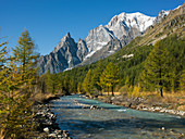 Snowcapped mountain by river in Aosta Valley, Italy