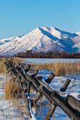 Fence in snow by mountains