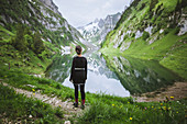 Frau am See in den Bergen in Appenzell, Schweiz