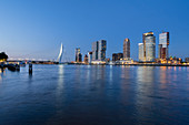 View of the Erasmus Bridge and the skyline at the cruise terminal in Rotterdam, Netherlands during the blue hour over the New Maas.