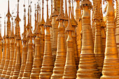 Shwe Inn Dein Pagoda - stupa field with golden stupas in the evening light at Inle Lake, Nyaung Shwe, Myanmar