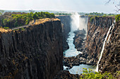 Victoria Falls viewed from the Zambian side, deep gorge with vertical sides, waterfall with torrents of white water.