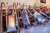 Snow-covered sledge on house wall, Himmelberg, Carinthia, Austria