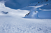 Snowboarder bei Tiefschneeabfahrt mit Spray am Fels, Hochfügen, Winter in Tirol, Österreich