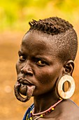 Frau des Mursi-Stammes mit Modifikationen an Unterlippe und Ohrläppchen, um Tonscheiben zu halten, Mago Nationalpark, Omo Tal, Äthiopien