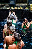 Ausländische Besucher baden am Wassertempel Tirta Empul, Bali, Indonesien