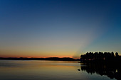 Späte Dämmerung mit Lichtstrahlen hinter einem Hügel, Orsjön, Tomterna, Västernorrland, Schweden