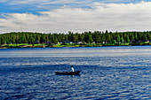 Eine Puppe sitzt in einem Ruderboot und angelt, Umeälven, Lycksele, Västerbottens Län, Schweden