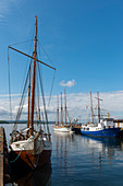 View of old sail boats docked in the harbor in front of the city hall in Oslo, Norway.
