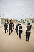 Mariachi band walking and carrying their instruments