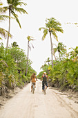 Couple riding bikes on sandy path
