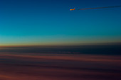 Airplane with contrails at dusk