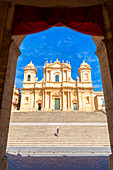 Tourist climbing the stairs of St nicholas church cathedral of Noto, Siracusa province, Sicily, Italy