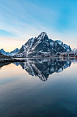 Bergreflexion in der Bucht von Reine bei Sonnenuntergang im Winter, Reine, Nordland, Nordnorwegen, Norwegen