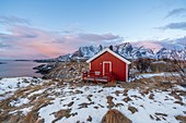Traditional fishermen house in winter at dawn. Hamnoy, Nordland county, Northern Norway, Norway.