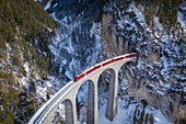 Aerial view of the famous Bernina Express passing over the Landwasser Viaduct. Filisur, Canton of Grisons, Switzerland, Europe.