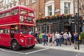 United Kingdom, London, former London bus used for ceremonies passing by a pub