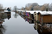 Boathouses in winter on the Peene Canal in Neukalen, Mecklenburg Lake District, Mecklenburg Switzerland, Mecklenburg-Western Pomerania, Germany