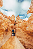 Couple stands in rock gate in Bryce Canyon, Bryce Canyon National Park, Utah, USA, North America